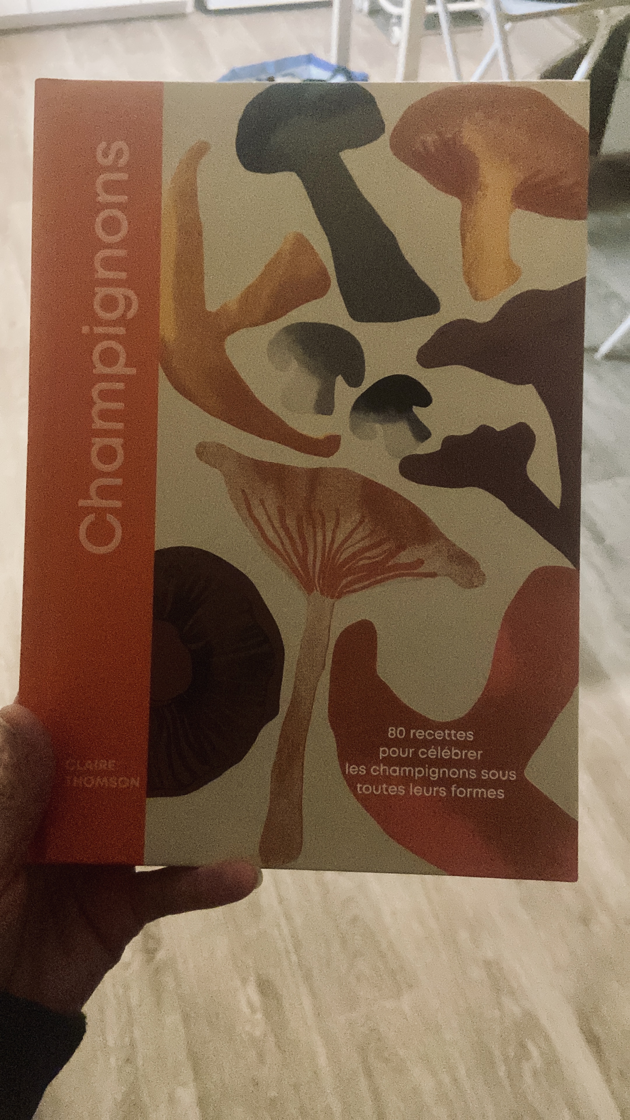 Livre de cuisine sur les champignons tenu à la main